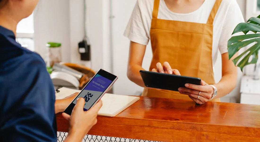 client règle sans contact sa note auprès de la responsable munie d’une tablette grâce au WIFI Pro du spécialiste IT Saphico